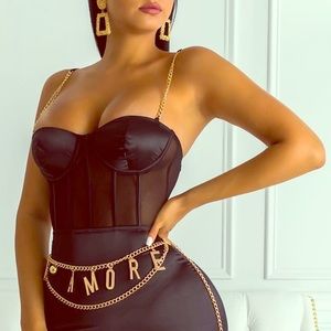 Black body suit with gold chains straps